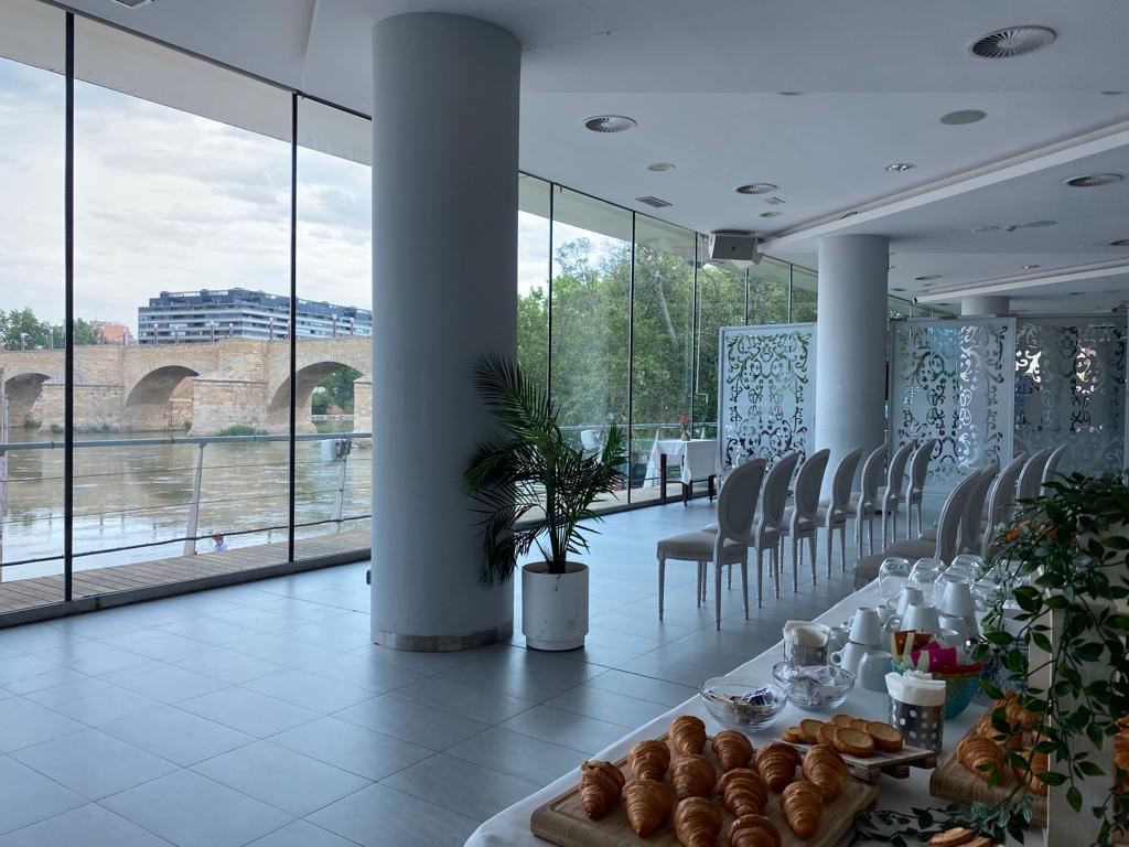 mesa con comida desayuno en salón con vistas al río